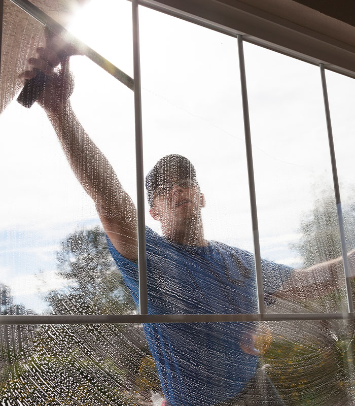 Man cleaning window of a home