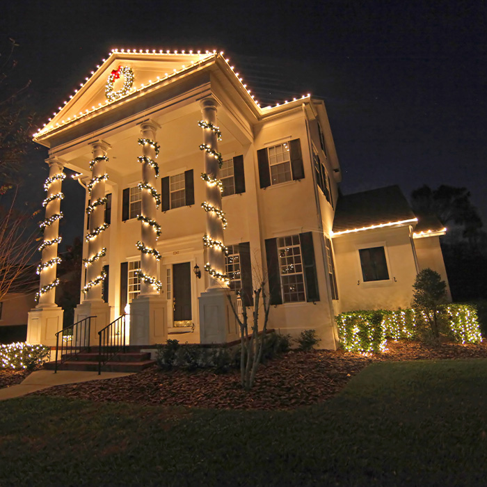 A colonial house with a lot of Christmas lights